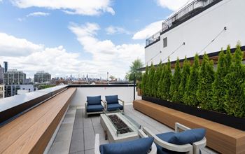 a rooftop terrace with furniture and a view of the city